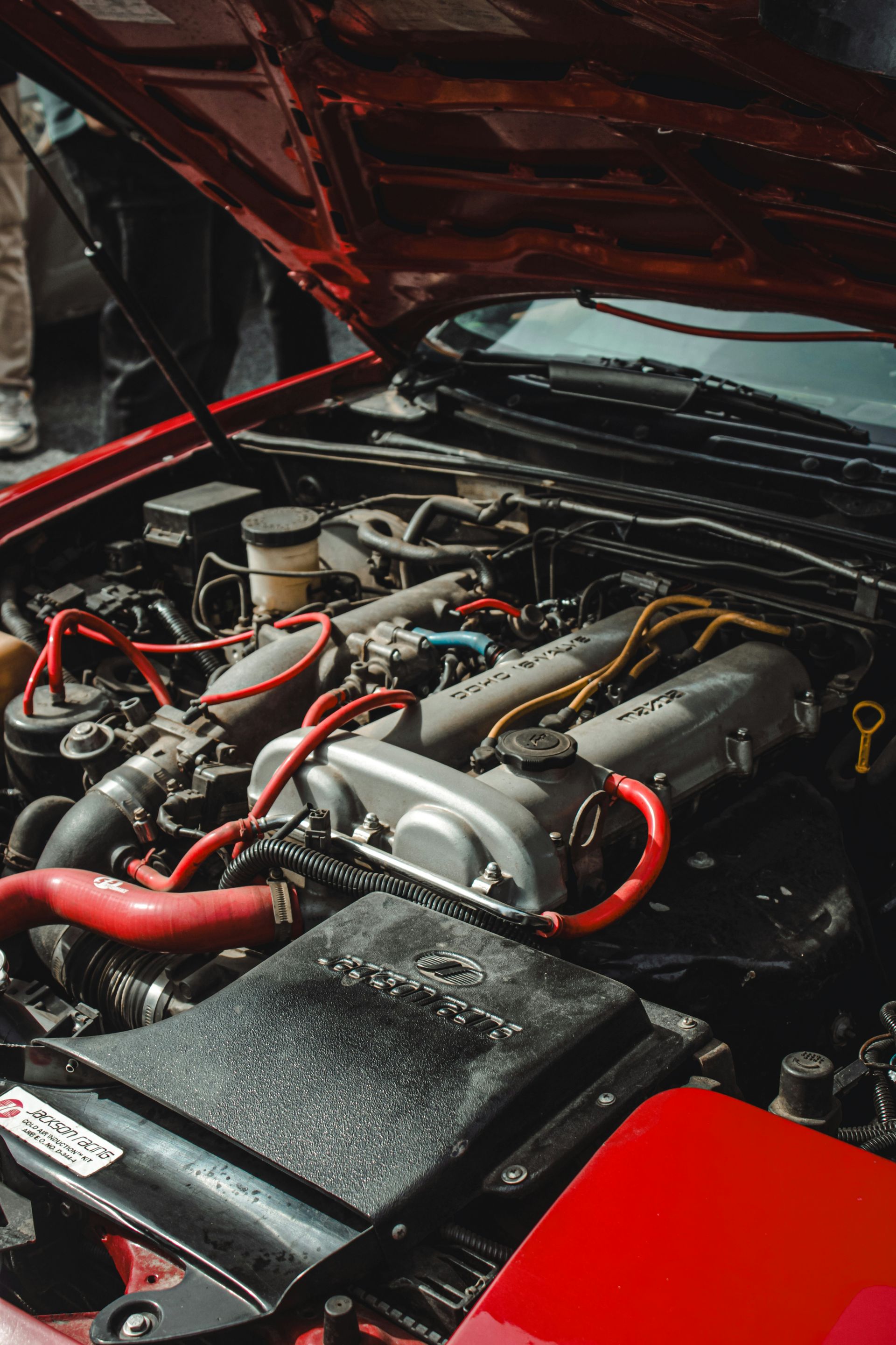 the engine of a red car with its hood open